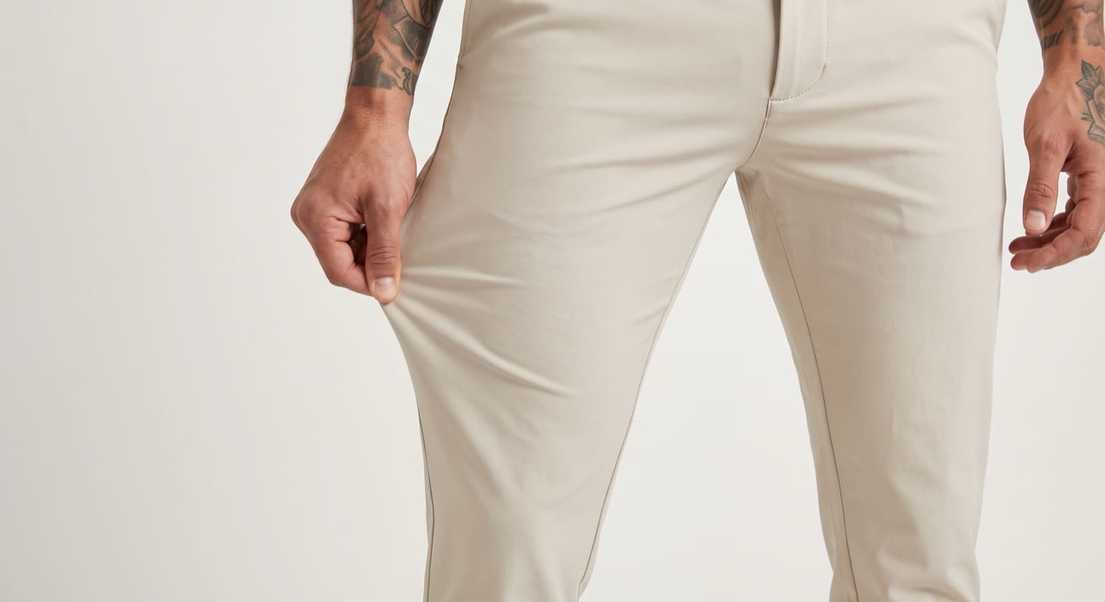 A generated product shot of cream trousers on a studio backdrop.
